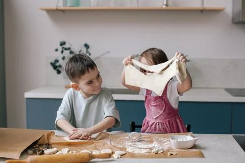 Siblings making cookies, preparing Easter. Stock Photos