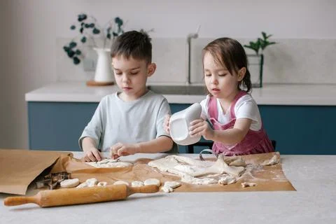 Siblings making cookies, preparing Easter. Stock Photos