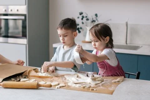 Siblings making cookies, preparing Easter. Stock Photos