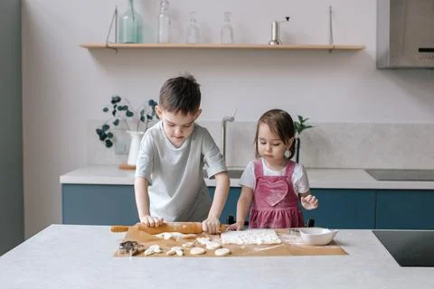 Siblings making cookies, preparing Easter. Stock Photos