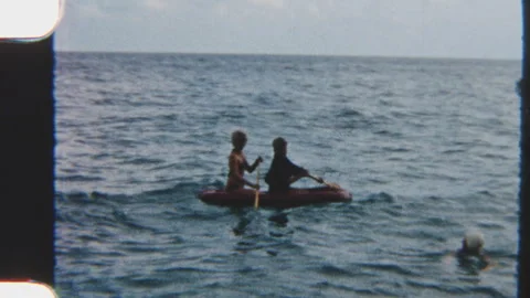 Siblings Paddling Inflatable Boat In Shallow Ocean Waters Stock Footage 322133413