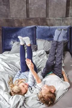 Siblings playing on bed Stock Photos