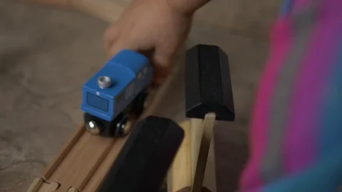 Siblings playing with a wood train Stock Footage 129524085