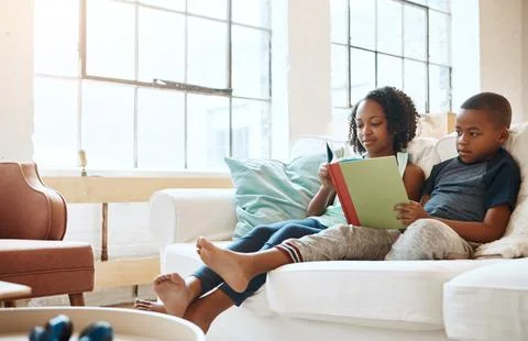 Siblings that read together need each other. a little brother and sister reading Foto stock