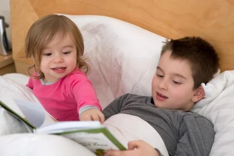 Siblings reading Stock Photos