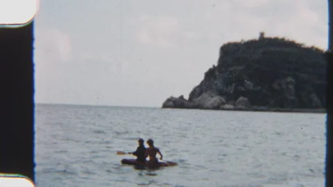 Siblings Riding An Inflatable Boat On Ocean Waters With Coastal Cliffs Stock Footage 322133455