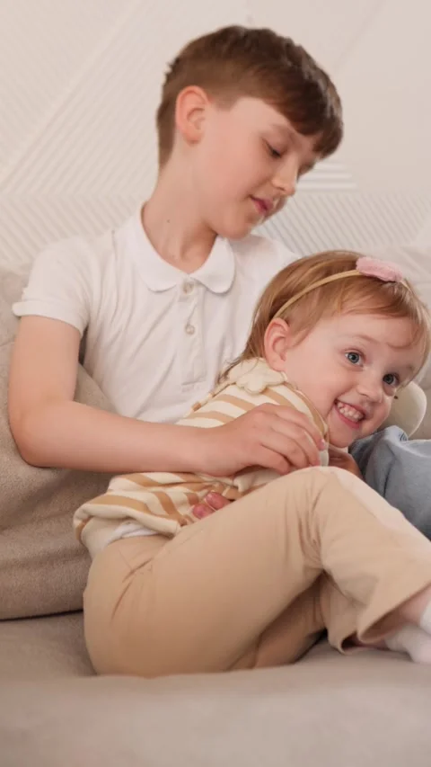 Siblings Sharing a Heartwarming and Cozy Moment Together While Sitting on a Stock Footage 312056434