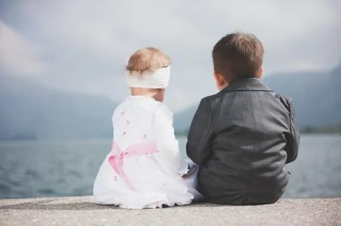 Siblings sitting by the lake Fotos de archivo