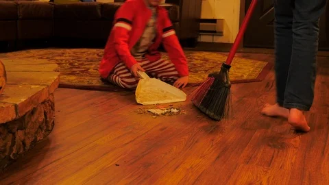 Siblings sweeping a dirty floor using teamwork. Stock-Footage 85641688