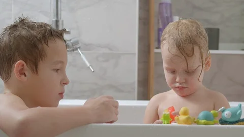 Siblings taking a bath and playing with toys Stock Footage 124622544