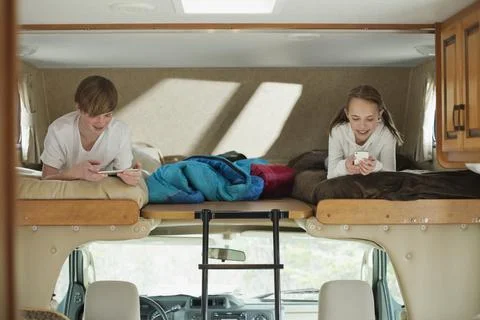 Siblings using computer technology in camper Stock Photos
