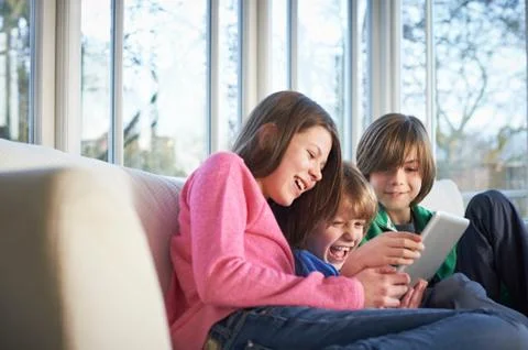 Siblings using digital tablet together Stock Photos