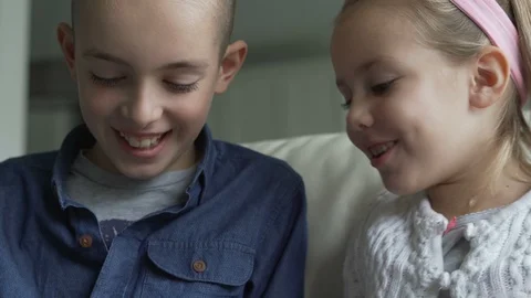 Siblings using the tablet together in living room Stock Footage 100175192