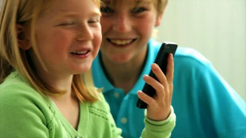 Siblings view content on smartphone. Stock Footage 88367643