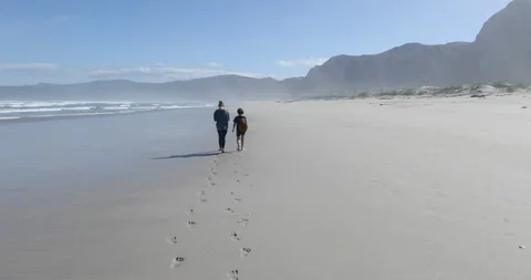 Siblings walking on beach, Walker Bay Nature Reserve, Western Cape, South Africa Stock Footage 202904930