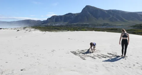 Siblings walking on beach, Walker Bay Nature Reserve, Western Cape, South Africa Stock Footage 202993802