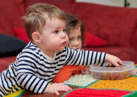 Siblings watching tv while eating grapes on Halloween Stock Photos