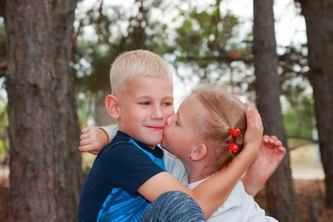 Siblinhgs: cute little girl kissing her brother. Childhood Stock Photos