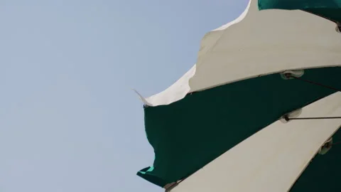 Sicily beach umbrellas blowing in wind near Mediterranean sea Stock Footage 328748382