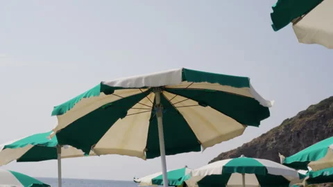 Sicily beach umbrellas blowing in wind near Mediterranean sea Stock Footage 328798444