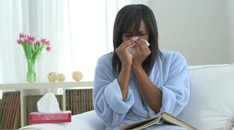 Sick African American woman blowing nose into tissue Stock Footage