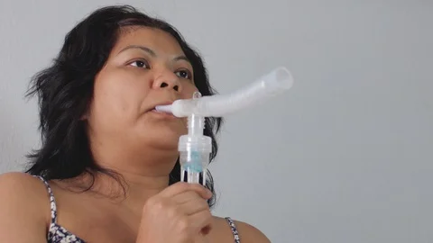 Sick asian female using nebulizer inhaler for asthma, coronavirus, flu at home Stock Footage 127996208