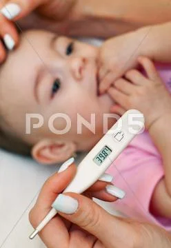 Sick baby being checked for fever. Stock Photos