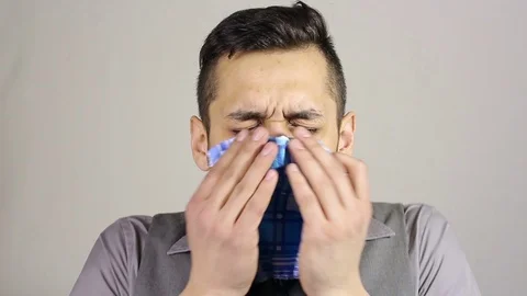 Sick bearded man blowing nose into tissue Stock Footage 73685907