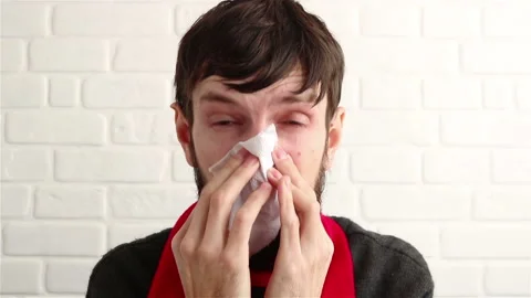 Sick bearded man feeling cold blowing his nose close up Stock Footage 149411887