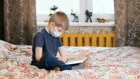 A sick boy on the bed is using a tablet Stock-Footage 127410823