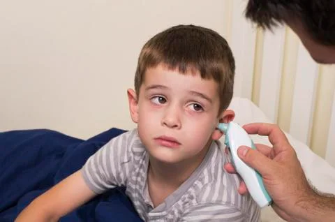 A sick boy gets his temperature taken Stock Photos