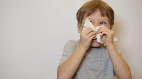 Sick boy using paper napkins. Boy has a virus, runny nose and headache. Stock Footage 221326198
