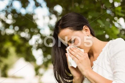 Sick brunette blowing her nose Stock Photos