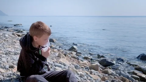 Sick child boy uses nebulizer inhaler mask to treatment of asthma on seaside. Stock-Footage 116176005