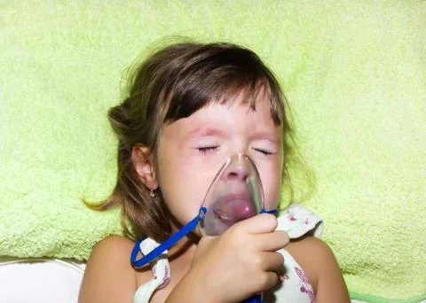 Sick child crying while inhaling Stock Photos