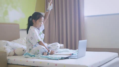 Sick child learning online class with teacher and friend at hospital Stock Footage 287897813