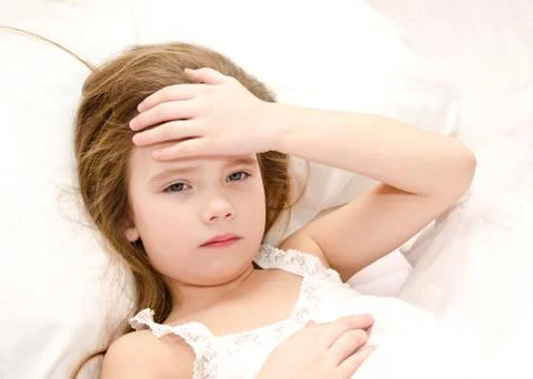 Sick child lying in the bed Stock Photos