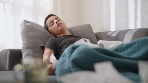 Sick Child Lying on Couch, Tired and Weak Surrounded by Tissues and Blanket Video stock 305703435