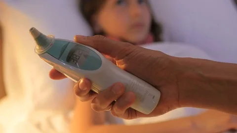A sick child is measured by temperature. A sick child. A child is ill.  Stock Footage 77409033