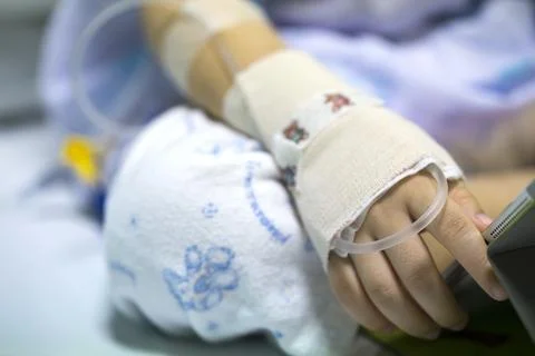 Sick child on a receiving a saline solution in hospital Fotos de archivo