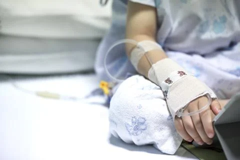 Sick child on a receiving a saline solution in hospital Fotos de archivo