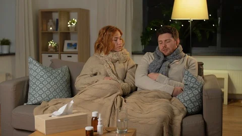 Sick couple with thermometer and tea at home Vidéo 127959931