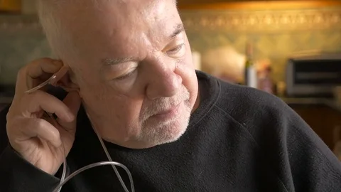 A sick elderly man removes the oxygen tubes from his nose in his home Stock Footage 71722719