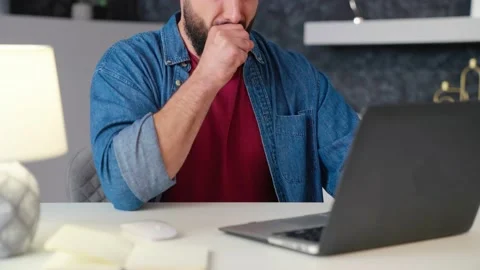 Sick freelance man working at home at computer coughing close-up Video stock 236588095