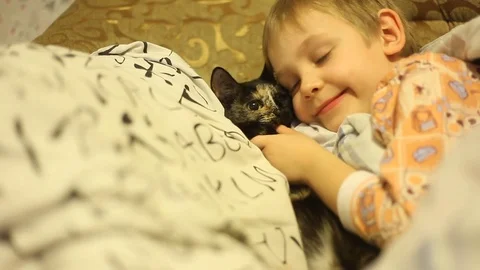 Sick little boy, lying in bed with a flu and a fever, watching TV Video stock 74490064