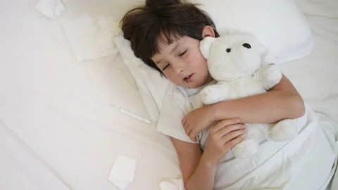 Sick little child boy lying on pillow in bed with toy bear. Tired lack of energy Stock Footage 168019922