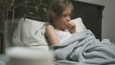 Sick little girl coughing lying in the b... | Stock Video | Pond5