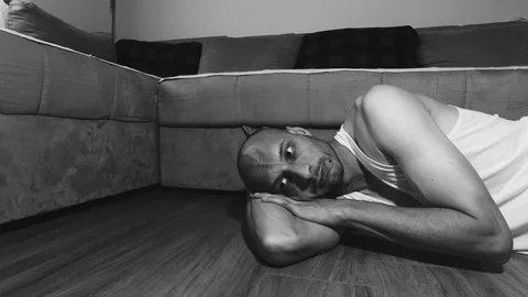 Sick lonely and depressed addict man lying on the floor Stock Footage 111443262
