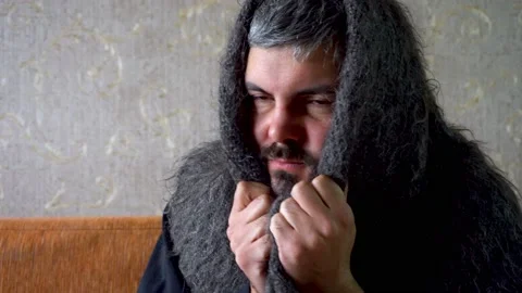 Sick man with a beard wrapped in a warm scarf 4K Stock Footage 118677637