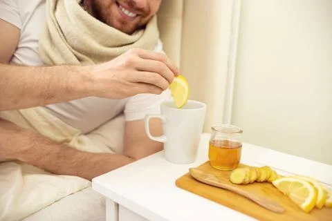Sick Man in Bed Adding Lemon into Tee Smilling. Man Ill in Bed Self Healing Stock Photos